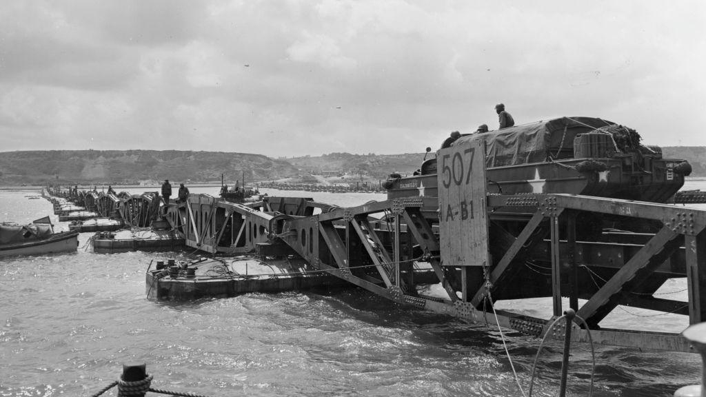 'Mulberry', the secret floating harbour being put to good use on Omaha beach in Normandy as a large truck drives over one of the pontoons.