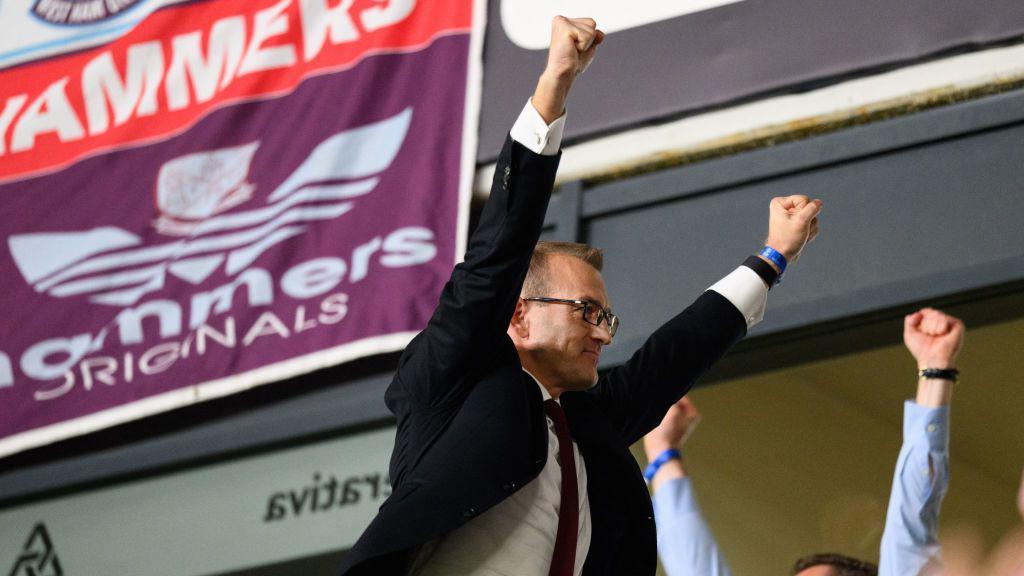 Daniel Křetínský pictured holding his arms in the air in celebration while watching West Ham at a football game