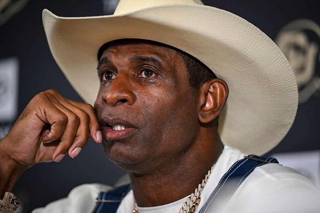 Deion Sanders wearing a beige cowboy hat speaks at a press conference Monday July 28.