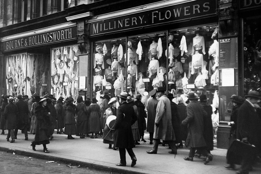 Christmas shoppers crowd the pavement outside the London store. Everybody is wearing black and looking glum