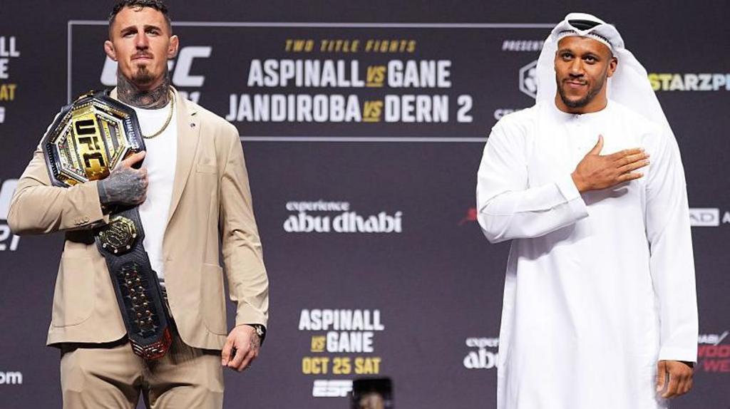 Tom Aspinall holds his UFC belt beside Ciryl Gane