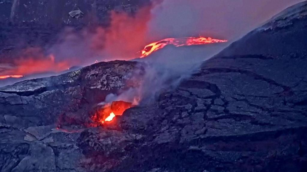 Steaming lava flows down volcano