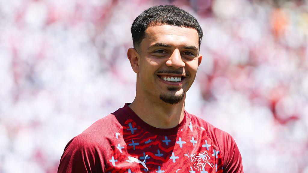 A smiling Zeki Amdouni in Switzerland's red training kit