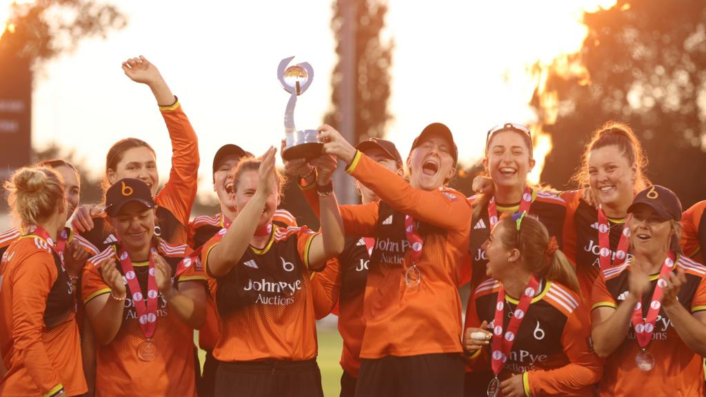 The Blaze celebrate winning the Charlotte Edwards trophy in 2026. Kirstie Gordon and Kathryn Bryce lift the trophy, whilst the team celebrates around them.