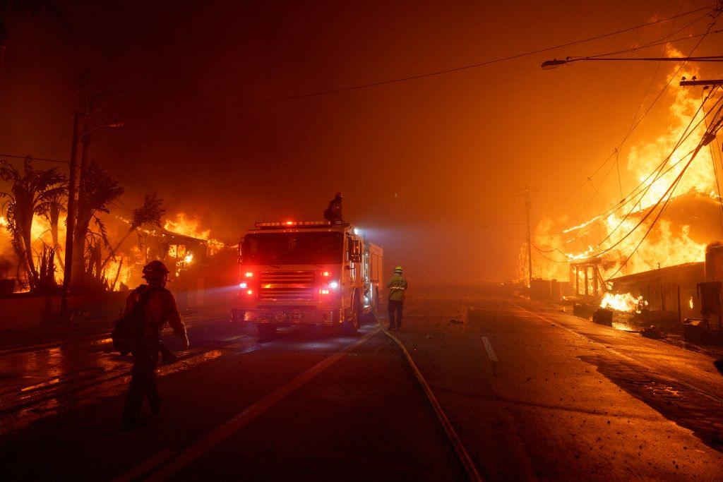 Flames from the Palisades Fire burn homes along Pacific Coast Highway.