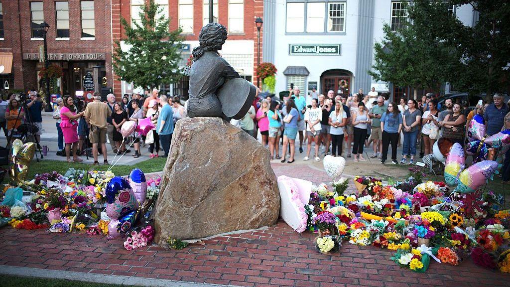  Fans pay tribute beside the Dolly Parton statue on the front lawn of the Sevier County Courthouse