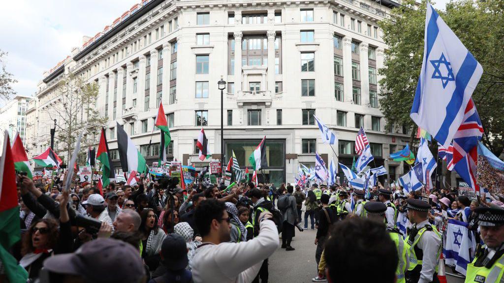 A line of police officers stands between pro-Palestinian protesters and counter-protesters 