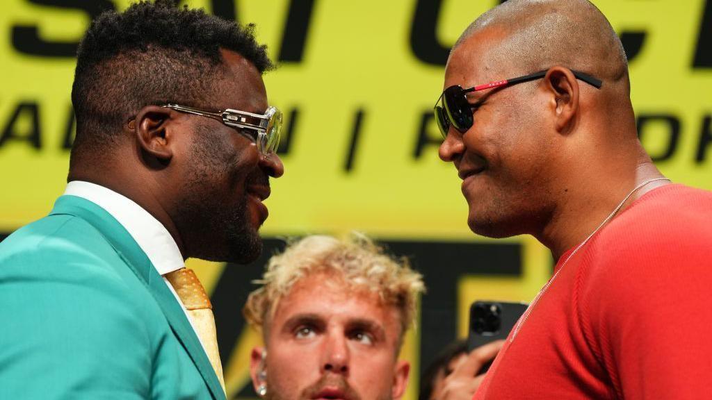 Francis Ngannou faces off with Renan Ferreira, both smirking