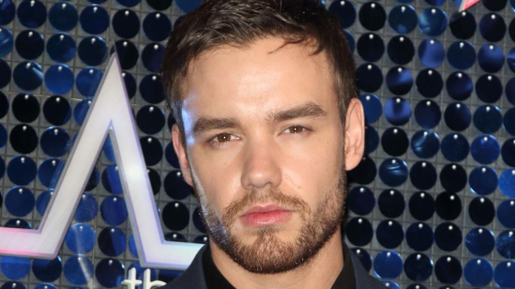 Liam Payne is unsmiling as he looks at the camera 