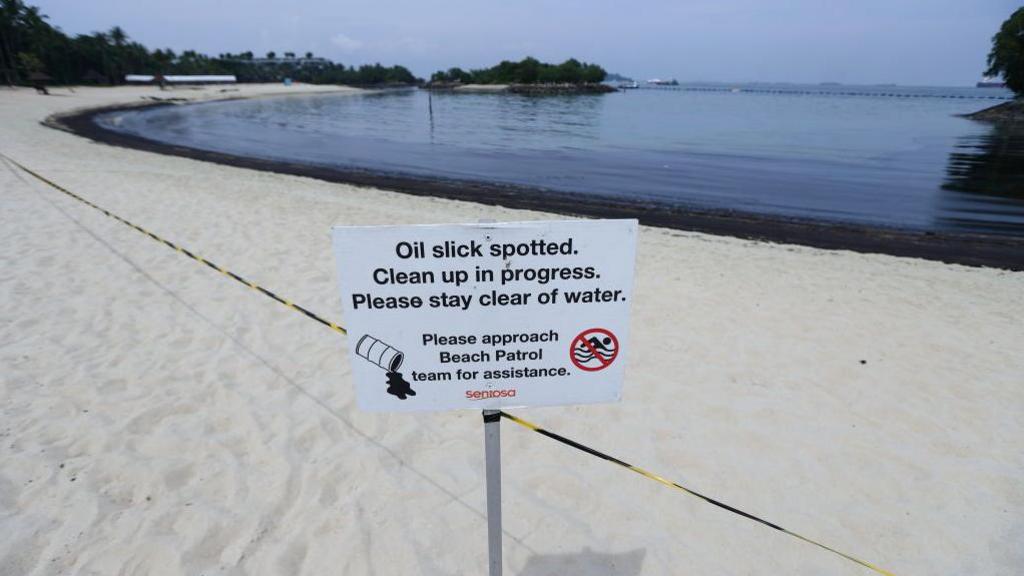 sign explaining that beach is closed for cleaning up oil spill