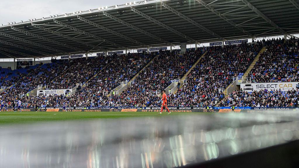 A general view of Select Car Leasing Stadium, home of Reading during the Sky Bet League One match between Reading FC and Lincoln City FC - a goalkeeper in orange can be seen on the pitch with stands full of supporters in the background