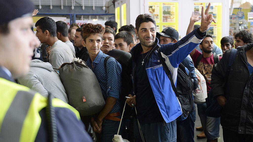 Refugees react to the welcome offers of Munich's residents after their arrival at the main train station in Munich