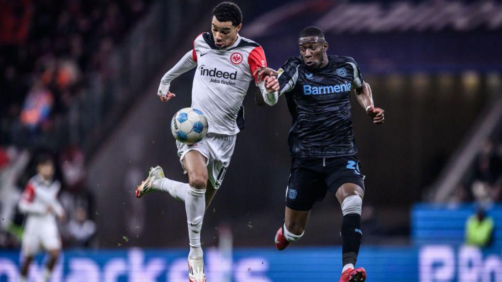 Hugo Ekitike takes on Nordi Mukiele of Bayer Leverkusen 