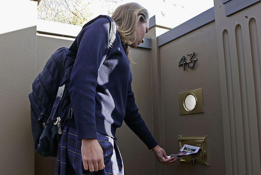 A fan hand-delivers a card to Kylie Minogue's home in Melbourne, Australia, after her cancer diagnosis