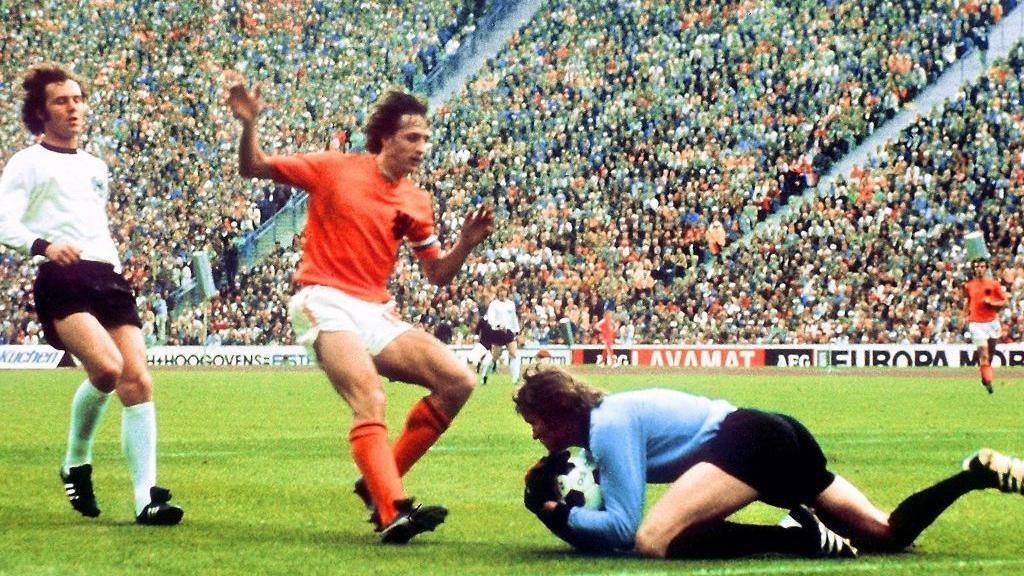 West German goalkeeper Sepp Maier catches the ball in front of Dutch forward Johan Cruyff as defender Franz Beckenbauer (left) looks on during the 1974 World Cup final. 
