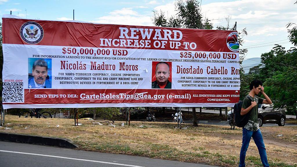 A man walks past a banner offering rewards for information leading to the arrest of Venezuelan President Nicolás Maduro and Interior Minister Diosdado Cabello in Villa del Rosario, Norte de Santander, Colombia.