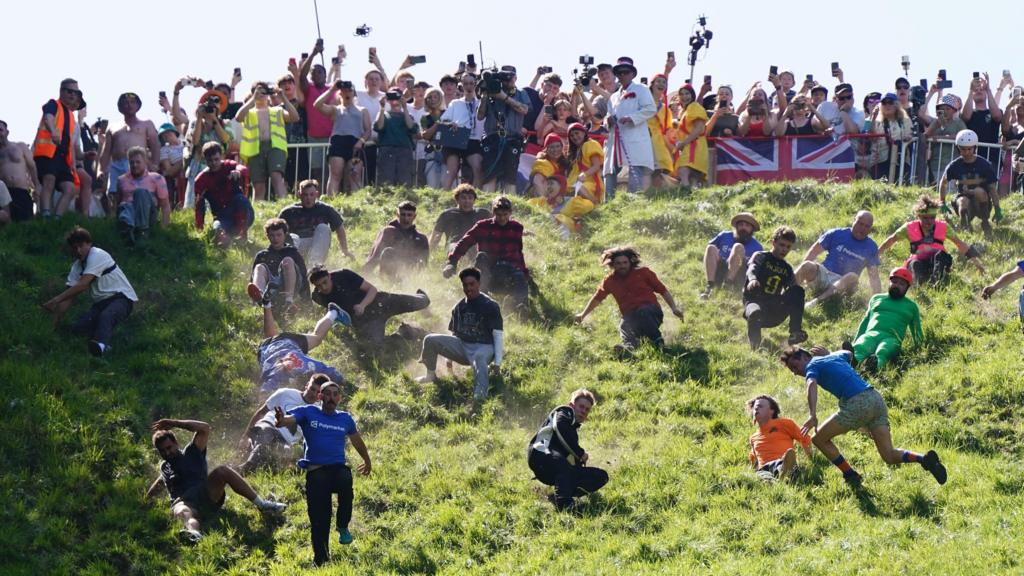 People run down the hill during the cheese rolling races in Gloucestershire