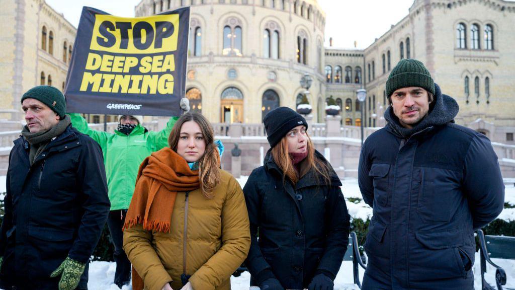 Norwegian member of Parliament Arild Hermstad, French climate activists Camille Etienne and Anne-Sophie Roux, and French actor Lucas Bravo attend a demonstration against seabed mining outside the Norwegian Parliament building in Oslo, Norway; one person in the background is holding a sign that reads: Stop deep sea mining