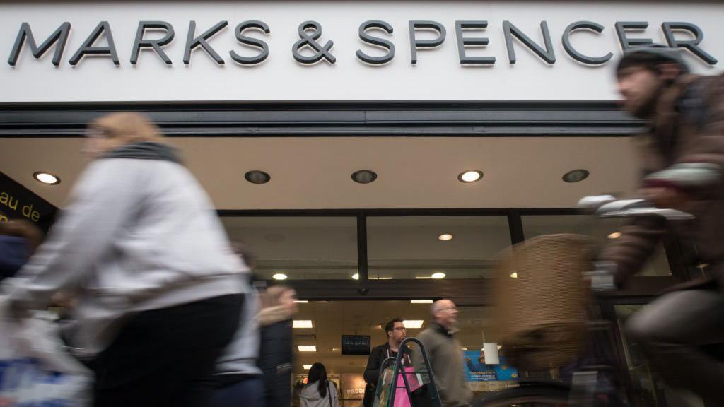 People walking past a Marks & Spencer store