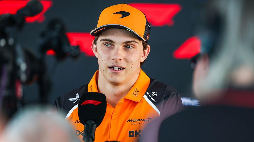 Oscar Piastri answers questions in the media pen in Qatar