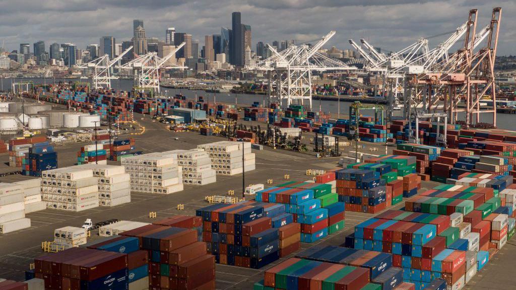 Shipping containers at the Port of Seattle in October 2024 with cranes and a city skyline in the background