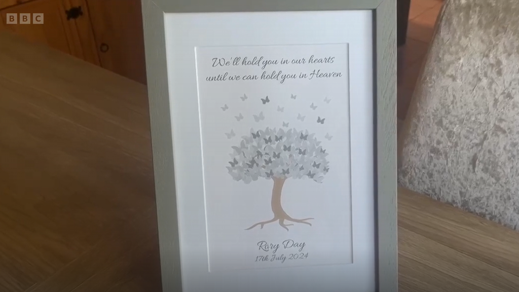 A framed paper shows a quote and the name and death date of a baby boy