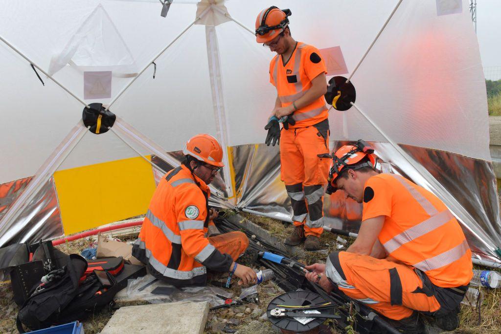 Workers operate to reconnect the signal box to the track in its technical ducts in Vald' Yerre, near Chartres on July 26, 2024