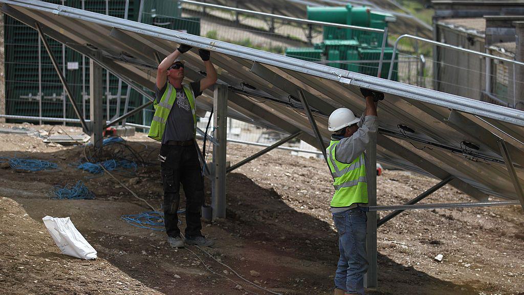 Construction workers putting up solar panels