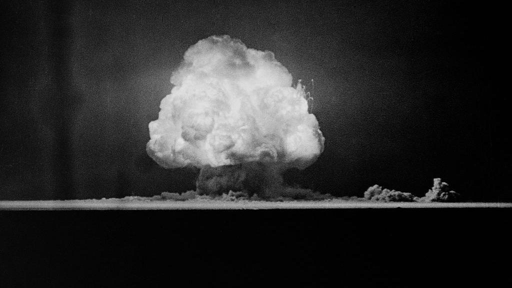 A mushroom cloud above the New Mexico desert seen in a black and white photo from 1945