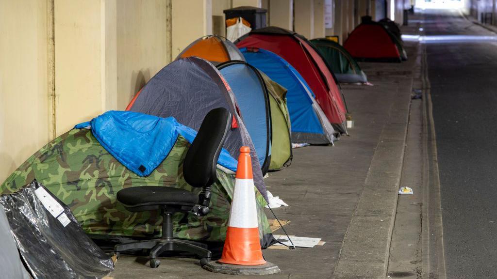 Homeless persons tents pitched in line on the pavement in an underpass near Blackfriars in the City of London.