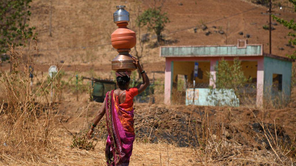 A woman in India carries water on her head