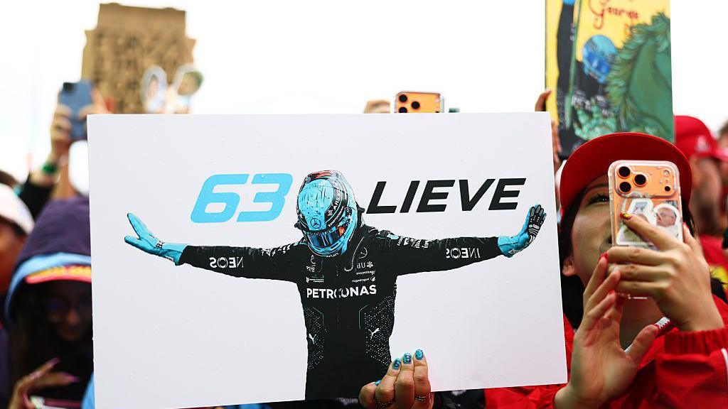 Fans hold up signs for George Russell 