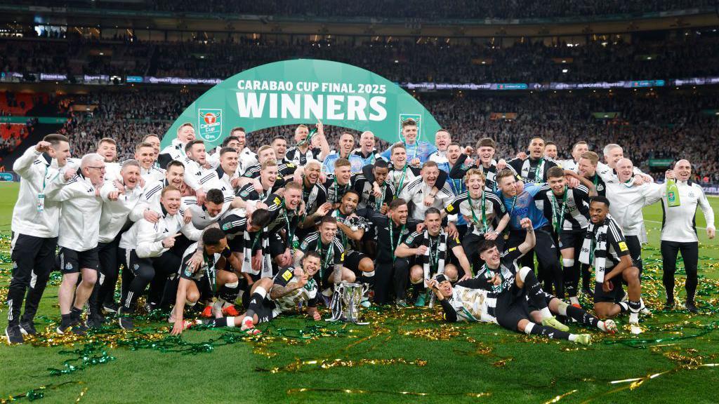 Newcastle players and staff celebrate their trophy win