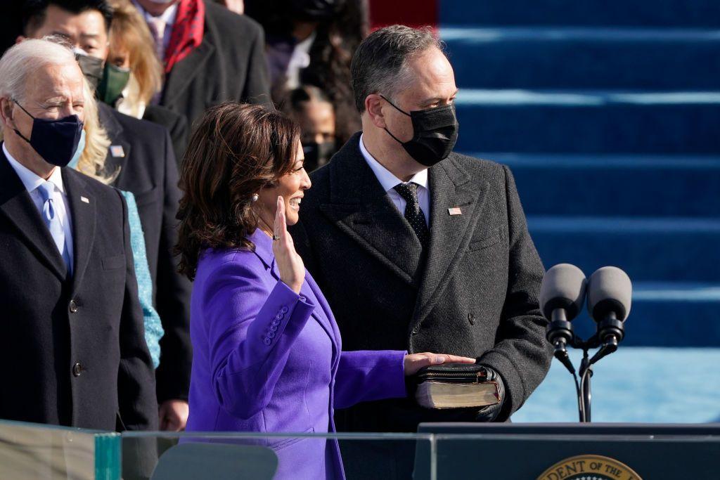 Doug Emhoff holds a bible as Kamala Harris is sworn in as vice-president