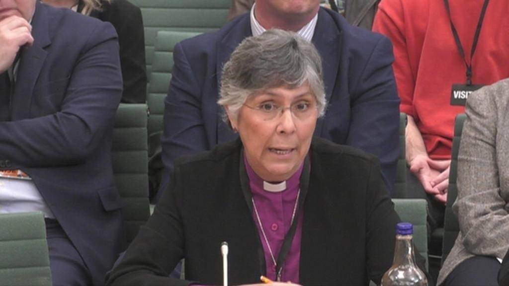 Reverend Dr Guli Francis-Dehqani is talking at a Commons committee in Westminster. She is wearing a purple shirt with a white dog collar. She is wearing glasses and has greying hair.