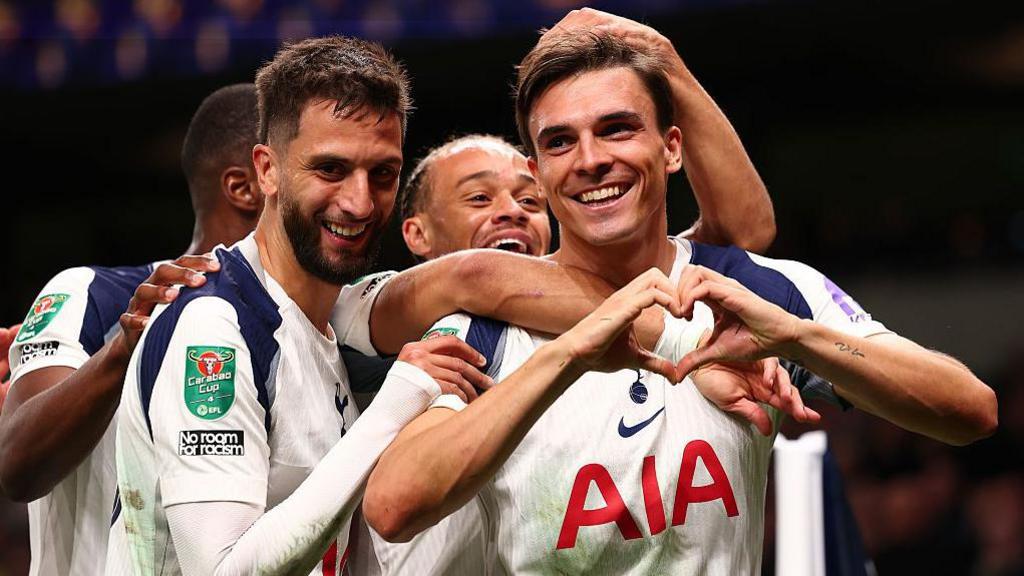 Joao Palhinha makes a heart shape with his hands as he celebrates with his Tottenham team-mates