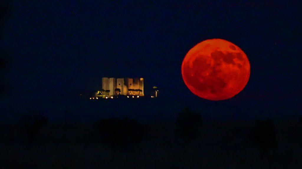 Strawberry Moon rising next to Castel del Monte in Andria, Italy.