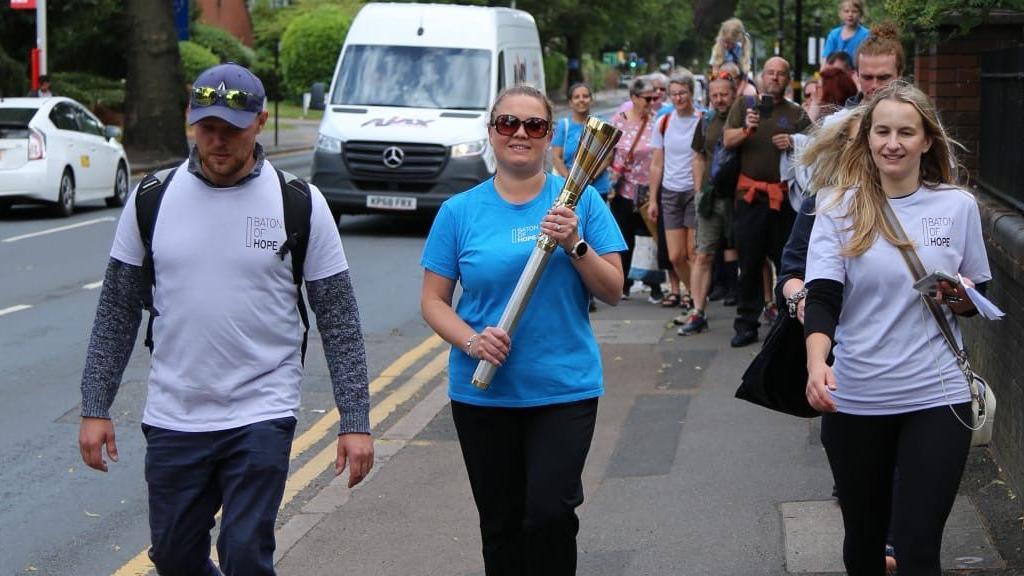 Claire Goring carrying the golden Baton of Hope in Birmingham
