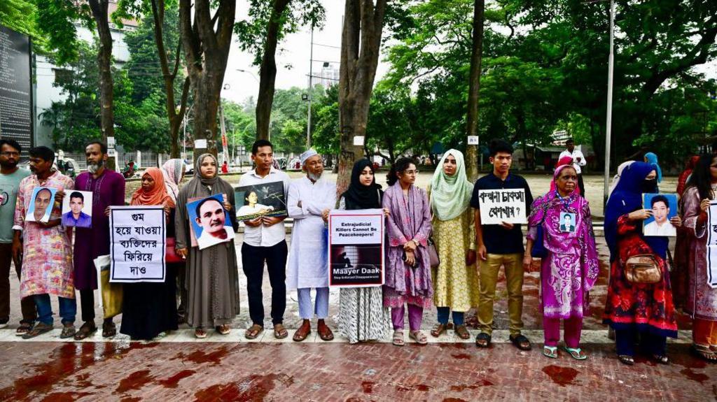 Relatives hold portraits of forcibly disappeared people, as they form a human chain to mark the International Day of the Victims of Enforced Disappearances, in Dhaka