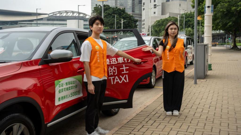 Polite Ambassadors are holding a taxi door open during a Publicity Campaign Launch Ceremony in Hong Kong, on 5 June, 2024