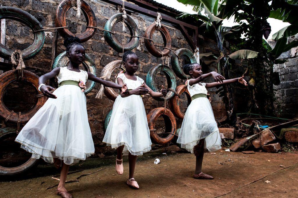 Ballet students from the Kibera-based Project Elimu warm up ahead of a public show in Kibera. They are wearing white tulle dresses.