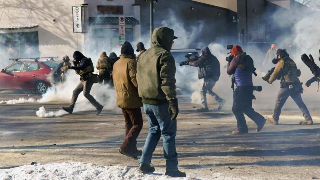Federal officers move on protesters during a confrontation following a fatal shooting
