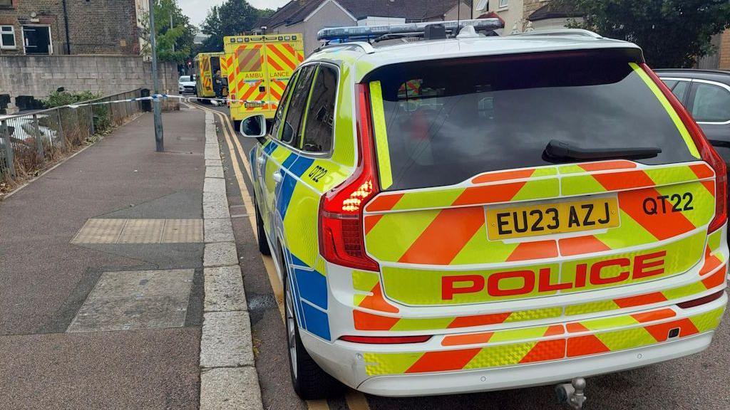 Essex Police car, two ambulances and a blue and white police cordon tape