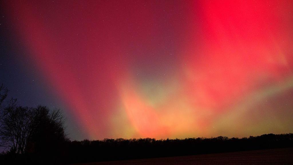 The aurora borealis glows above rural Monroe County as a strong geomagnetic storm from recent solar activity pushes the Northern Lights unusually far south on November 12, 2025, in Bloomington, Indiana. Displays were reported across the United States as far south as Texas, Alabama, Georgia, and north Florida. 