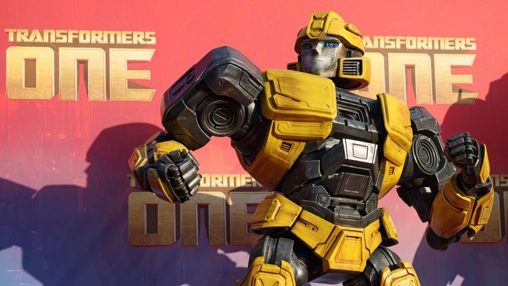 A Transformer statue next to a poster for a film
