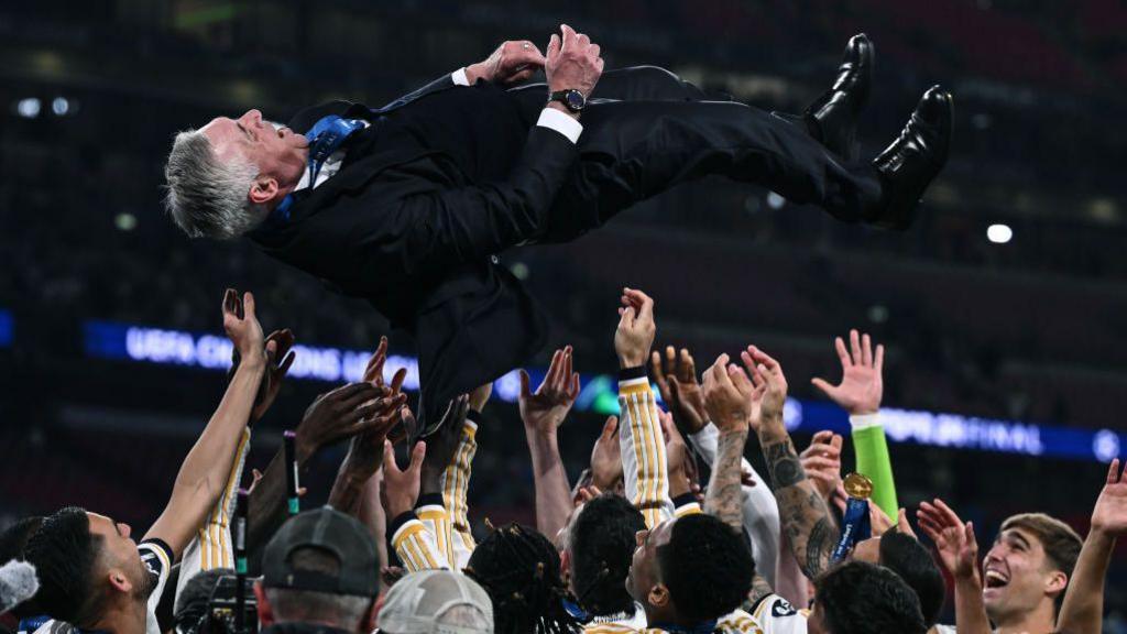 Airborne Carlo Ancelotti is hoisted aloft by Real Madrid's triumphant players