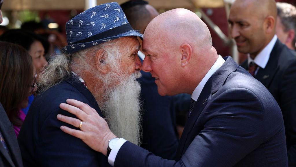 A Māori elder touches noses with Prime Minister Christopher Luxon