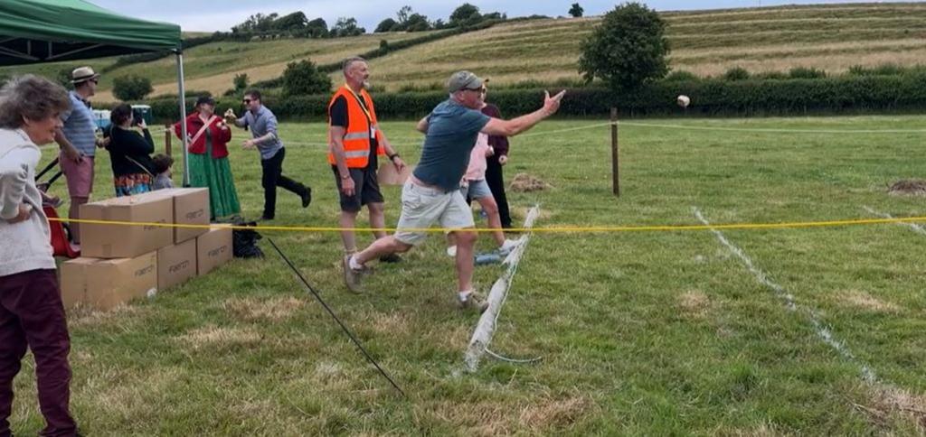Field with people lined up ready to throw Dorset Knob biscuits