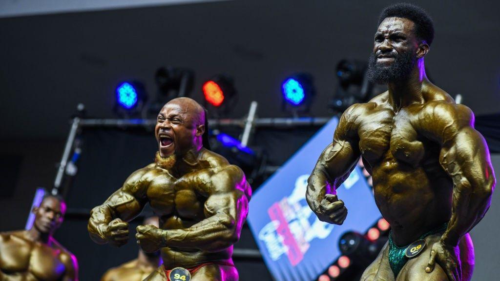 Two men flex their muscles during the Mr and Miss East Africa Bodybuilding Contest at the Sarit Centre in Westlands district of Nairobi, Kenya - Saturday 13 October 2024.