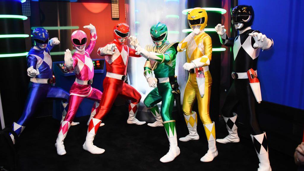 Actors dressed as Power Rangers pose at a comic book event in the US